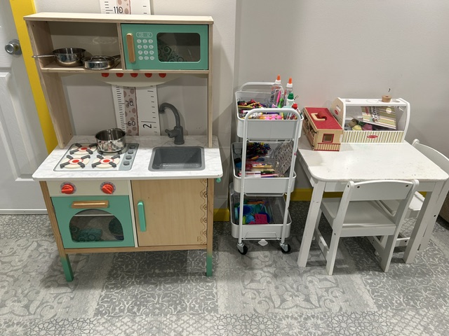 Play kitchen and art cart set up for open-ended play