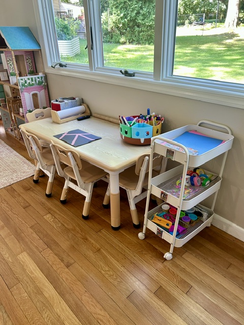 Craft table by a sunny window with organized supply cart